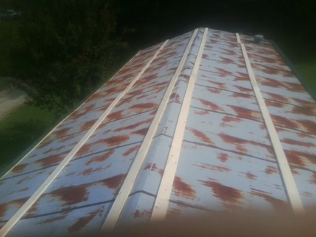 Rusted metal roof panels with new wood purlins before replacement — Storm Damage Roof Repair in Manitou Beach by Roofing Brothers