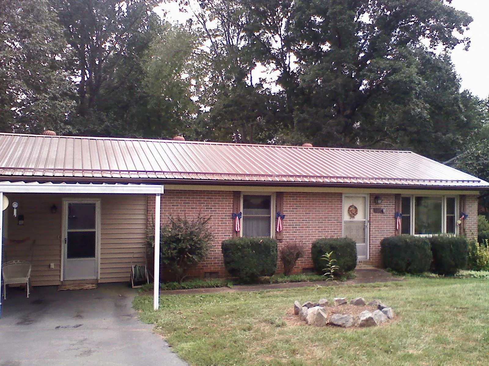 Bronze metal roof and carport on a brick ranch home — Roof Repair work by our crew in Manitou Beach